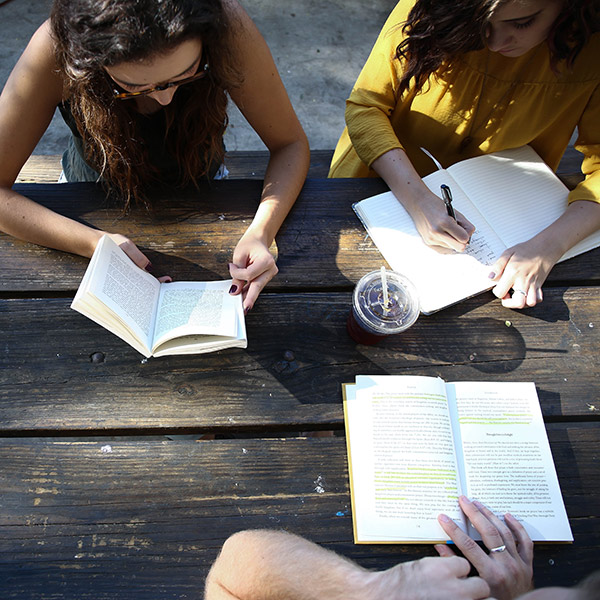Group reading books outdoors